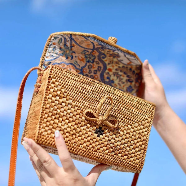 Bali rattan bag opened up and held to the blue sky
