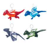 Four handmade felt flying dragon keychains are arranged against a stark white background. The unique handcrafted felt keychains include a red dragon with orange and white wings, a blue dragon with lighter blue and white wings, a gray dragon with white wings, and a green dragon with white wing markings. Each charming felt keychain is fitted with a metal keyring.