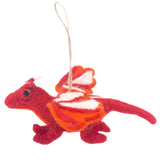 A scarlet red needle felted flying dragon ornament is suspended by a jute string against a plain white background. This 3D handcrafted dragon features a curled tail, four legs, and a small white horn. Its open wings are adorned with striking white and orange stripes.