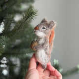 Handmade felt squirrel finger puppets holding acorn and nut, eco-friendly wool toys for kids, storytelling, or woodland pretend play.