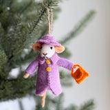 A handcrafted felt Queen Mousiebeth mouse ornament hangs on a Christmas tree. This elegant white felt mouse wears a lavender coat with two yellow buttons, a matching wide-brimmed hat, and holds an orange felt handbag. It features tan ears and a tan tail, with a jute string at the top for hanging.