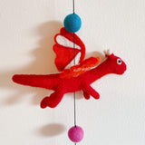 A vibrant Felt Dragon garland is displayed against a bright white background. This playful wool felt garland highlights a detailed red 3D pterosaur. It features white accents on its wings and horns, adding a whimsical touch.