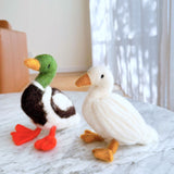 2 Needle Felted Duck Christmas Ornaments handmade by Ganapati Crafts Co. in Nepal sitting on a white table waiting to be put on a Christmas tree