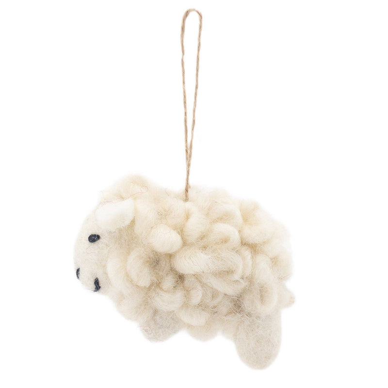 A felt sheep Christmas ornament from the Farmland Animals set is suspended by a jute string against a bright white background. This handmade felt sheep ornament is off-white, appearing soft and fluffy with a woolly texture. Small black felt details form its eye and mouth, adding charming character.