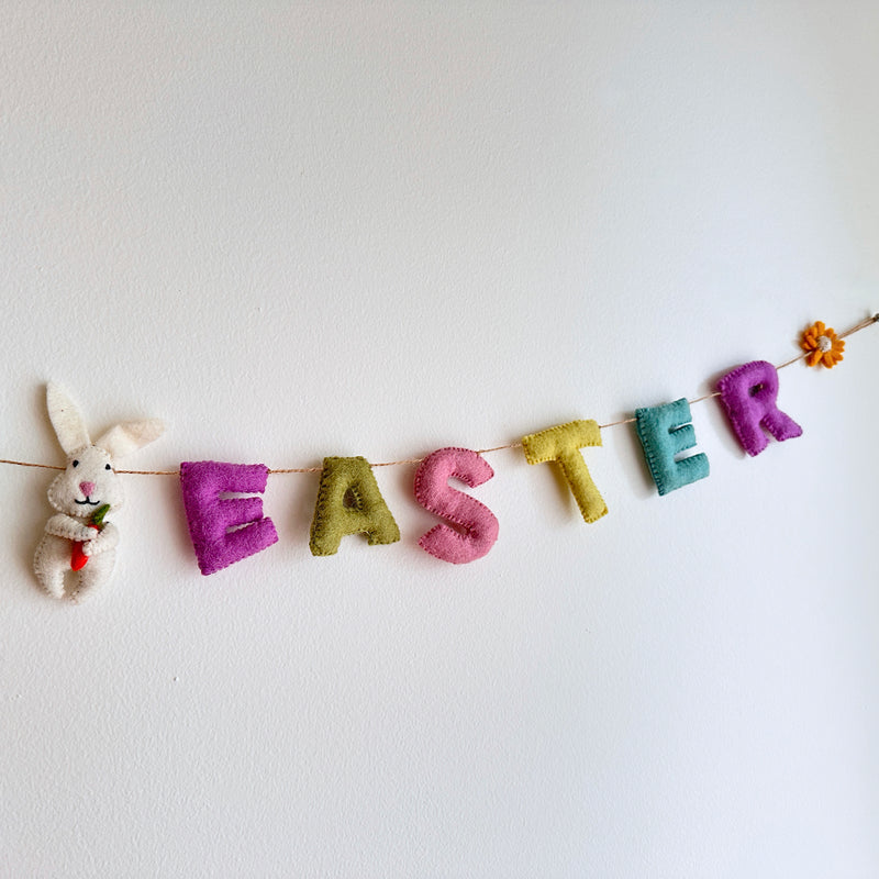 A decorative wool felt garland spelling out 'Happy Easter' in pastel colors, featuring bunnies, daisies, sunflowers, and eggs. The garland is made from sheep wool and has a festive design, perfect for hanging on walls or doorways during Easter celebrations.