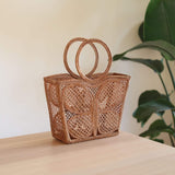 The Butterfly Rattan Handbag handmade by Ganapati Crafts Co. in Bali is sitting on a table looking stylish