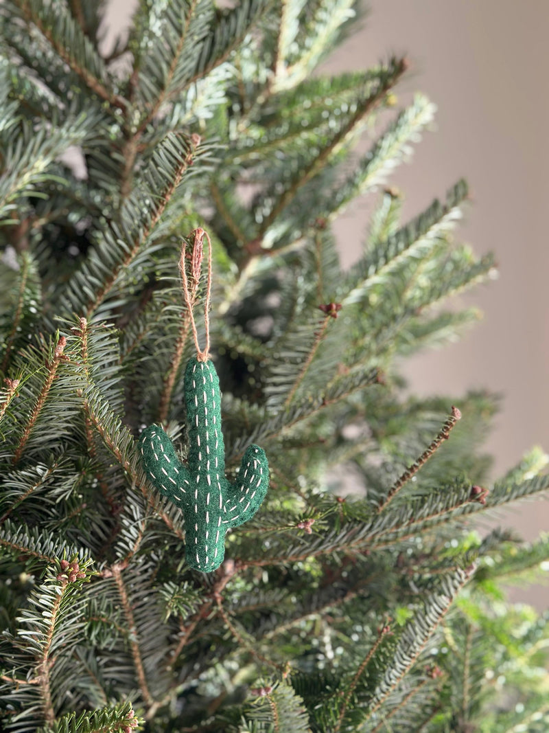 A handmade felt cactus ornaments by Deer Harbour Design hanging on a  Christmas tree