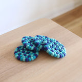 These ocean blue circle felt cup coasters are made with about half-inch felt balls. Each felt ball has been hand-stitched to each other, and it is heat resistant so that it can protect your tabletop burning from the hot cup.  This cup coaster set will add a lovely atmosphere to your table. - Ganapati Crafts Co.