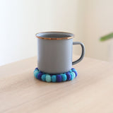These ocean blue circle felt cup coasters are made with about half-inch felt balls. Each felt ball has been hand-stitched to each other, and it is heat resistant so that it can protect your tabletop burning from the hot cup.  This cup coaster set will add a lovely atmosphere to your table. - Ganapati Crafts Co.