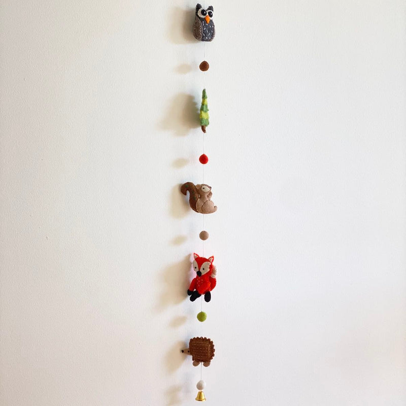 Our lovely felt forest animal garland is handmade in Nepal of 100% wool. It's needle felted, and 3D designed. The garland is about 4' long and consists of 5 felted forest animals - owl, tree, fox, hedgehog, squirrel, and with a bell at the end. It looks great from any angle.