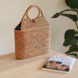 The Tall Malboro Bali Rattan Straw Handbag handmade by Ganapati Craft in Bali where all the Bali Rattan Straw Bags are made is sitting on a table looking stylish