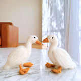 2 Needle Felted Duck Christmas Ornaments handmade by Ganapati Crafts Co. in Nepal sitting on a white table waiting to be put on a Christmas tree